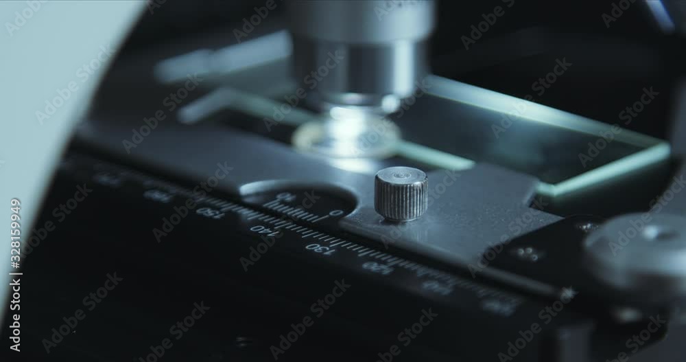 Crop closeup shot of microscope in the laboratory, scientist is conducting study examines the sample on a slide Crop closeup shot of microscope in the laboratory, scientist is conducting study examines the sample on a slide