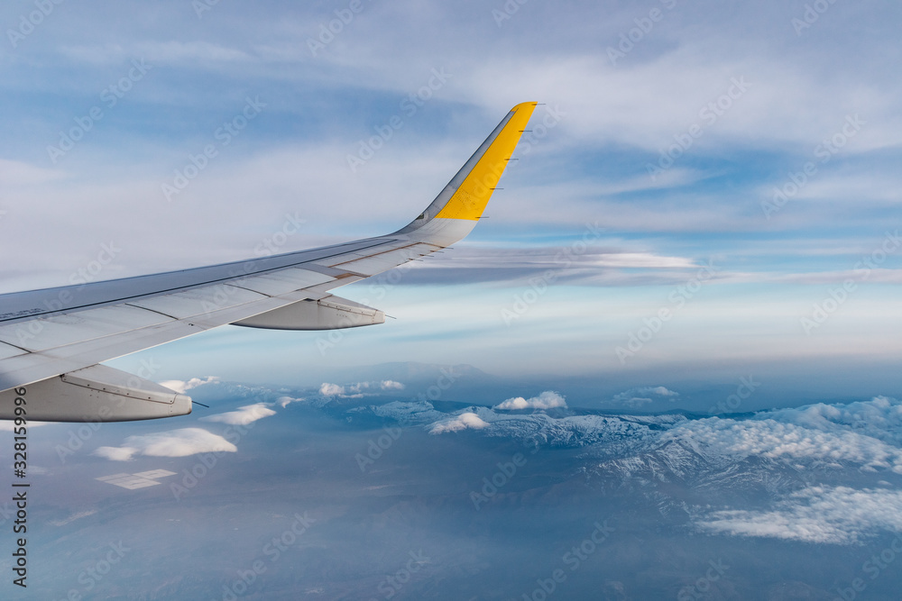 ala de avión airbus a320 sobre sierra nevada, españa. se ve el cielo azul con nubes y las montañas