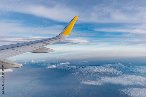 ala de avión airbus a320 sobre sierra nevada, españa. se ve el cielo azul con nubes y las montañas
