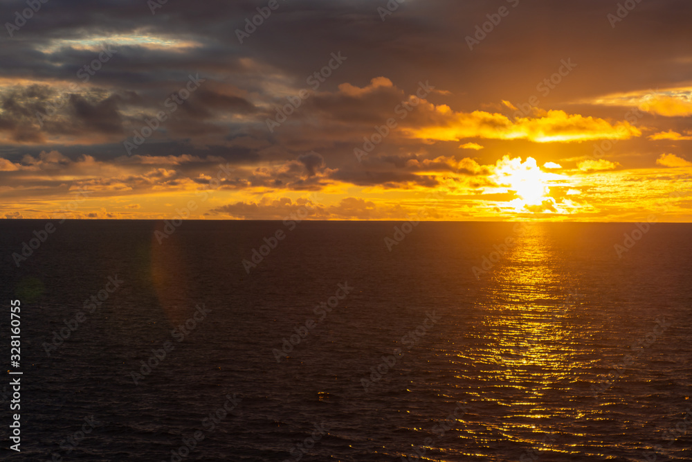 Amazing sunset with colorful clouds and dark ocean water, nature background