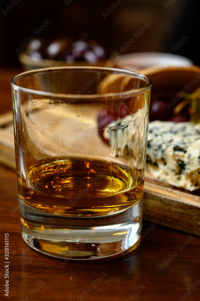 Tasting of original scottish cheese and whisky, plate with scottish cheeses and variety of Scotch in glasses Tasting of original scottish cheese and whisky, plate with scottish cheeses and variety of Scotch in glasses