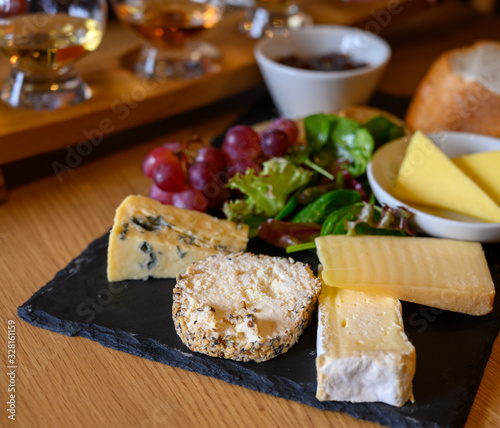 Tasting of original scottish cheese and whisky, plate with scottish cheeses and variety of Scotch in glasses