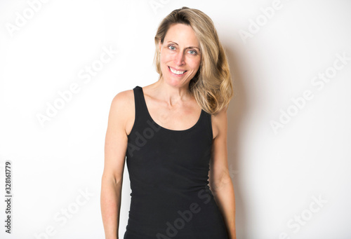 beautiful woman wearing black tank top over white studio wall.