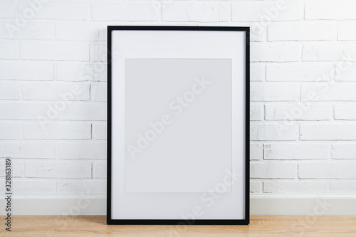 Black frame for painting or poster on white brick wall