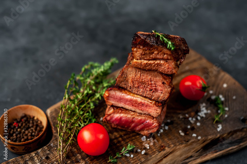 four grilled steaks with spices on a stone background. Four types of meat frying Rare, Medium, Medium Well, Well Done