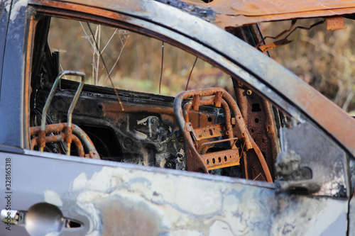 burnt car on the forest, rusty metal