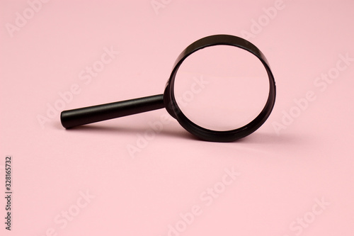 Magnifying glass on a pink background. Top view. Copyspace for your text