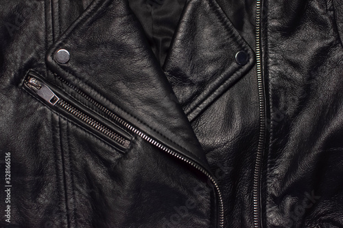 Close up details Black women's leather jacket top view. Fashionable modern trendy women's clothing. Vintage biker jacket. Black genuine leather texture