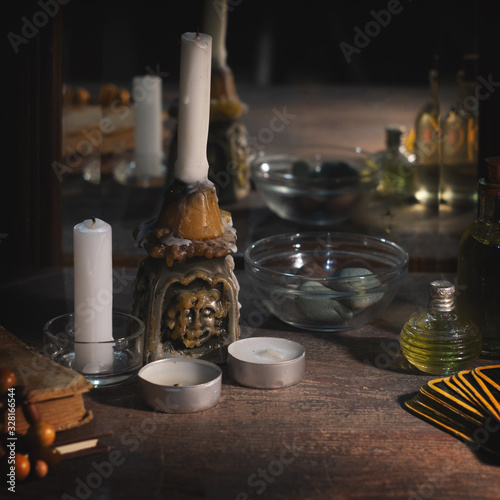 Bild auf Leinwand Burning candles, fortune-telling cards and tincture bottles are reflected in an