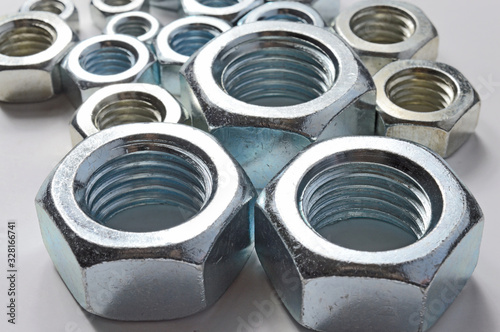 New chrome screw-nut of different sizes on a white background. Concept.