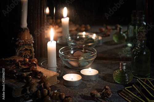 Konstfotografi Burning candles, fortune-telling cards and tincture bottles are reflected in an