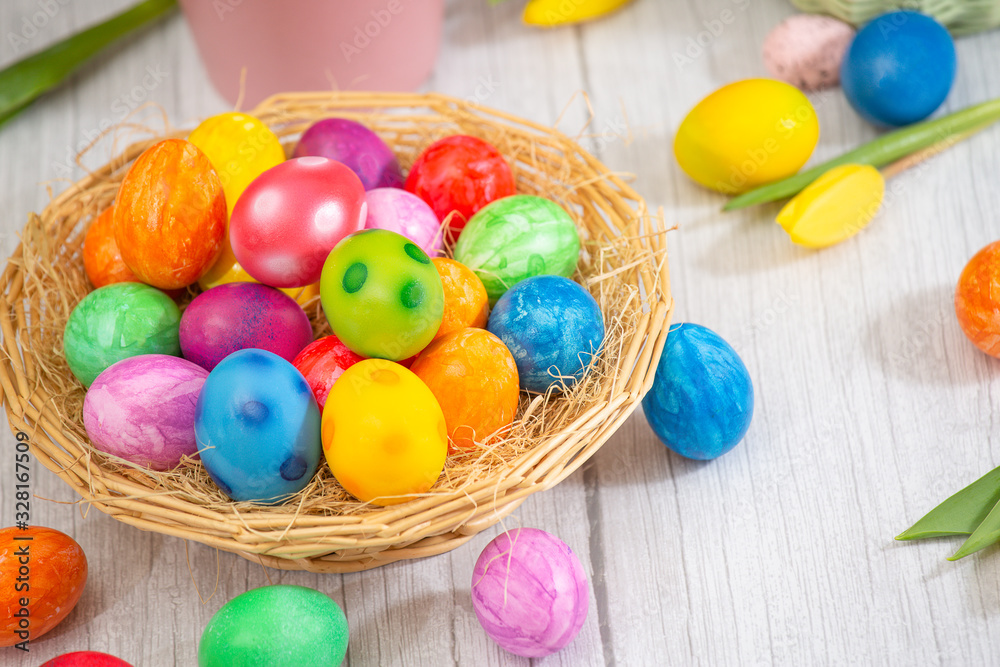 Beautiful group Easter eggs in the spring of easter day, red eggs, blue, purple and yellow in Wooden basket with tulips on the wood table background Beautiful group Easter eggs in the spring of easter day, red eggs, blue, purple and yellow in Wooden basket with tulips on the wood table background