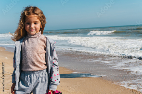 Little girl on the sandy shore of the ocean