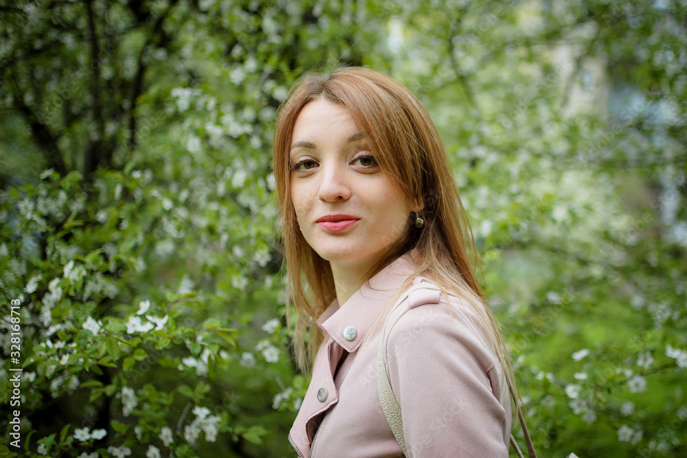 Happy smiling woman on flowering tree background in the garden during early spring. Allergy concept Happy smiling woman on flowering tree background in the garden during early spring. Allergy concept