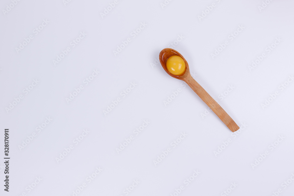 Egg yolk in a wooden spoon. Egg yolk in a wooden spoon.