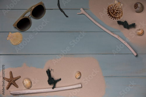 Muscheln mit Sand auf einem blauem Holz Hintergrund..