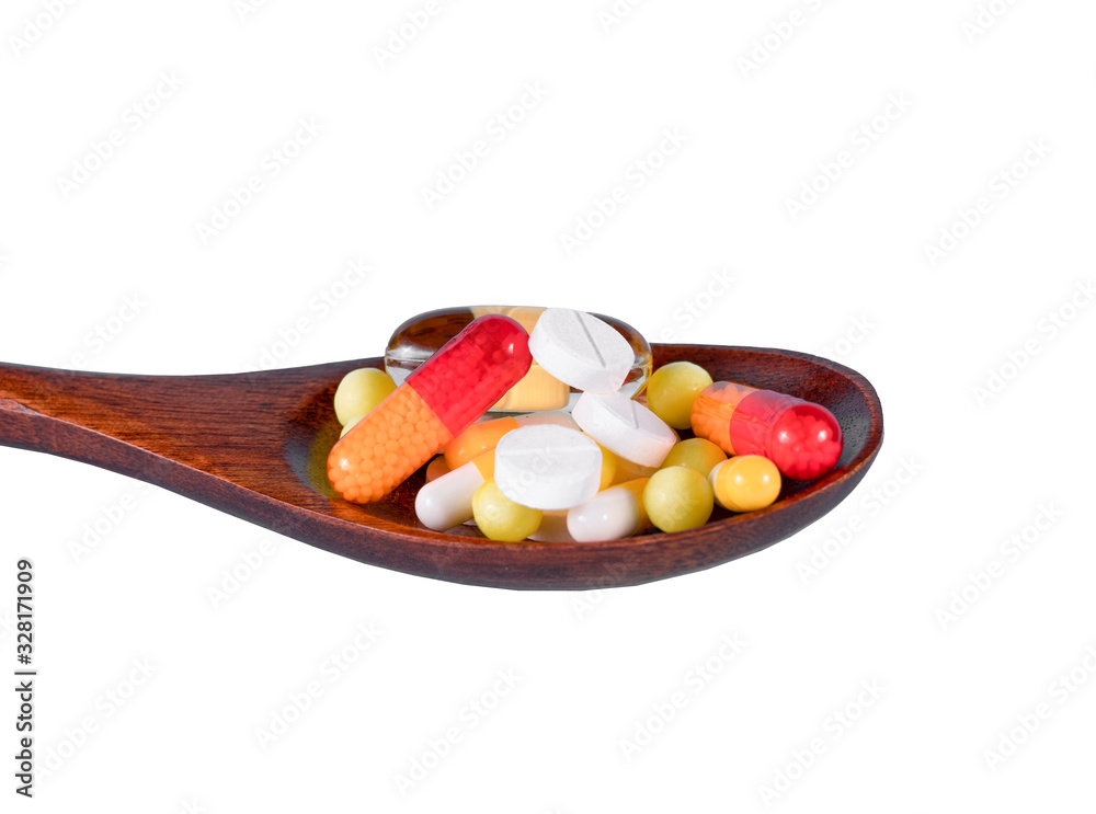 White Tablets In Wooden Spoon Against White Background White Tablets In Wooden Spoon Against White Background
