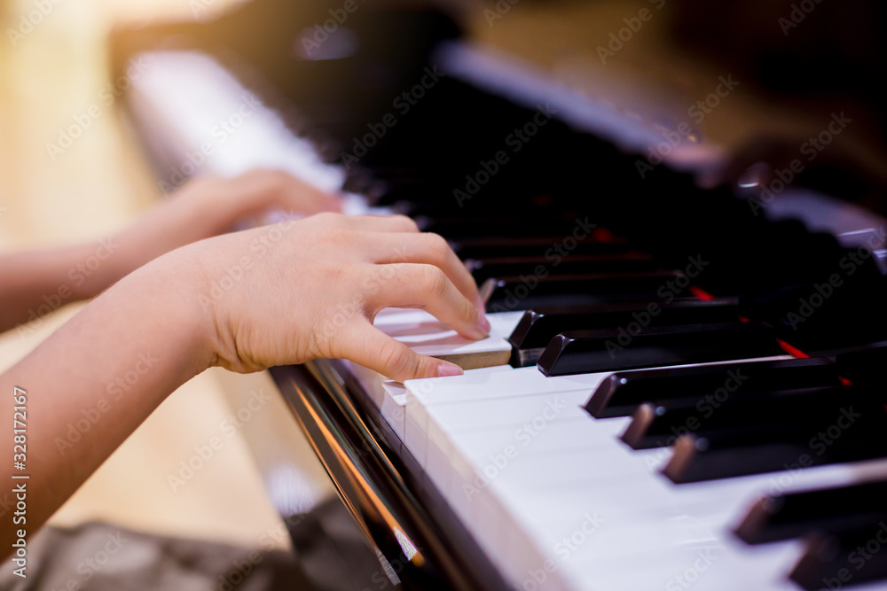 Selective focus to kid fingers and piano key to play the piano. Selective focus to kid fingers and piano key to play the piano.