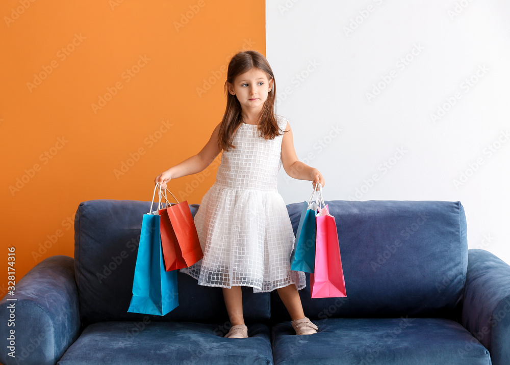 Stylish little girl with shopping bags on sofa Stylish little girl with shopping bags on sofa