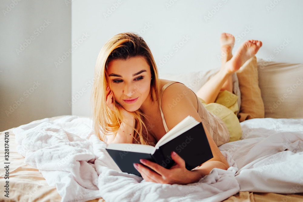 Blonde woman in pajamas having breakfast in bed Blonde woman in pajamas having breakfast in bed