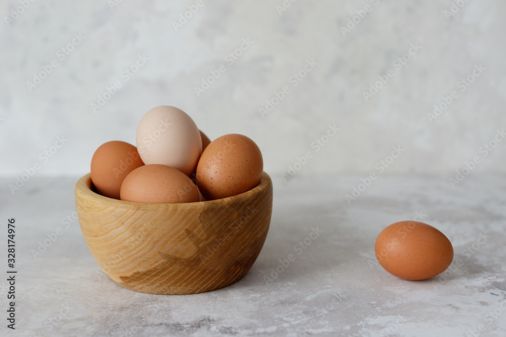 Rustic eggs in a wooden plate, one egg next to the plate. Rustic eggs in a wooden plate, one egg next to the plate.