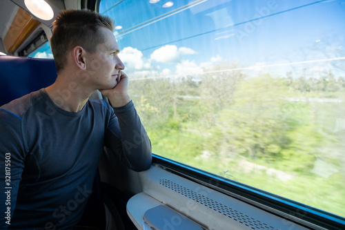 Young man sitting in the train and looks out the window
