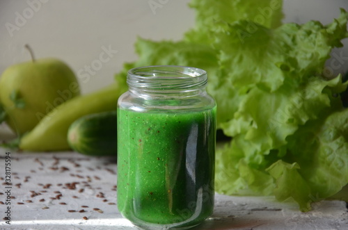 Detox diet. Green smoothie with different vegetables on white wooden background copy space. diet vegitarians healthy low calorie food. salad, greens, green apple chia or flax linen seeds photo