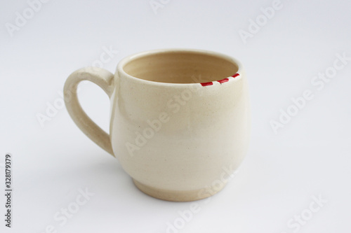 ceramic mug with red spots painted with overglaze paint. handmade. photo