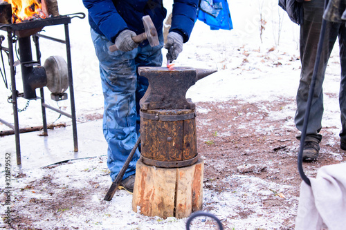 a blacksmith forges a product on an anvil