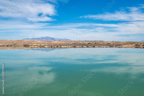 Blue sky in between clouds reflecting in the teal green waters of Bowman Reservoir, a dam along the Muddy River in Overton, Clark County, Nevada, USA