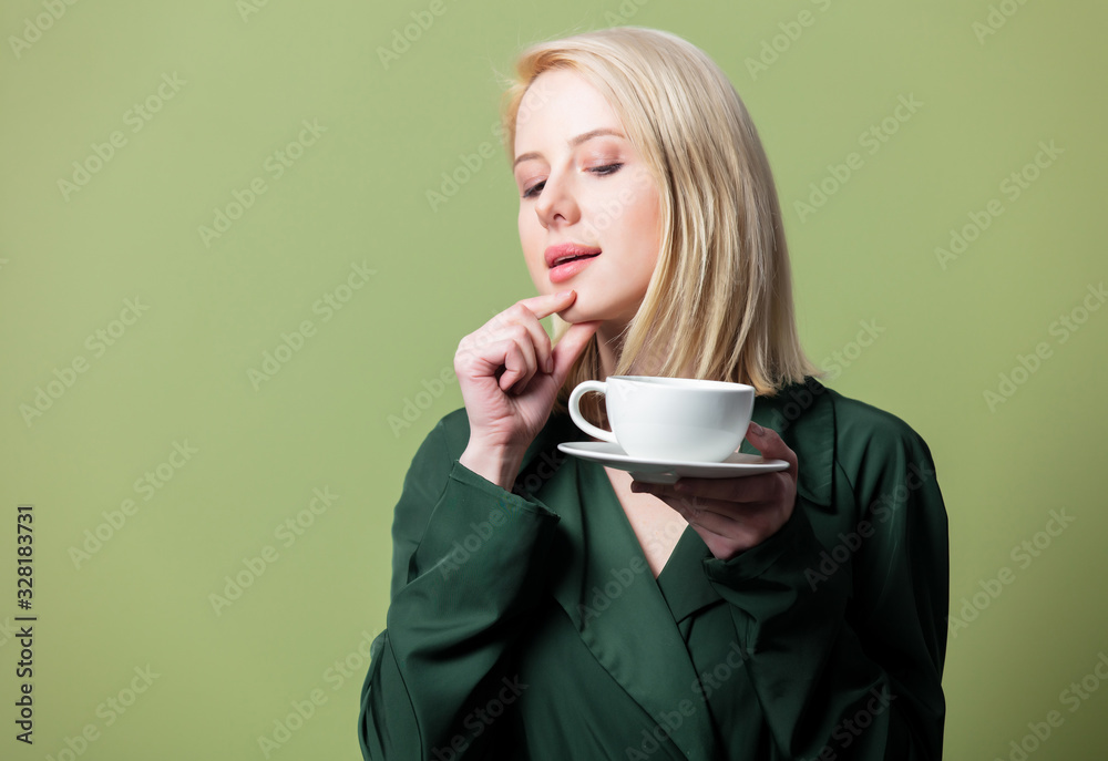 Blonde woman in cloak with cup of coffee Blonde woman in cloak with cup of coffee