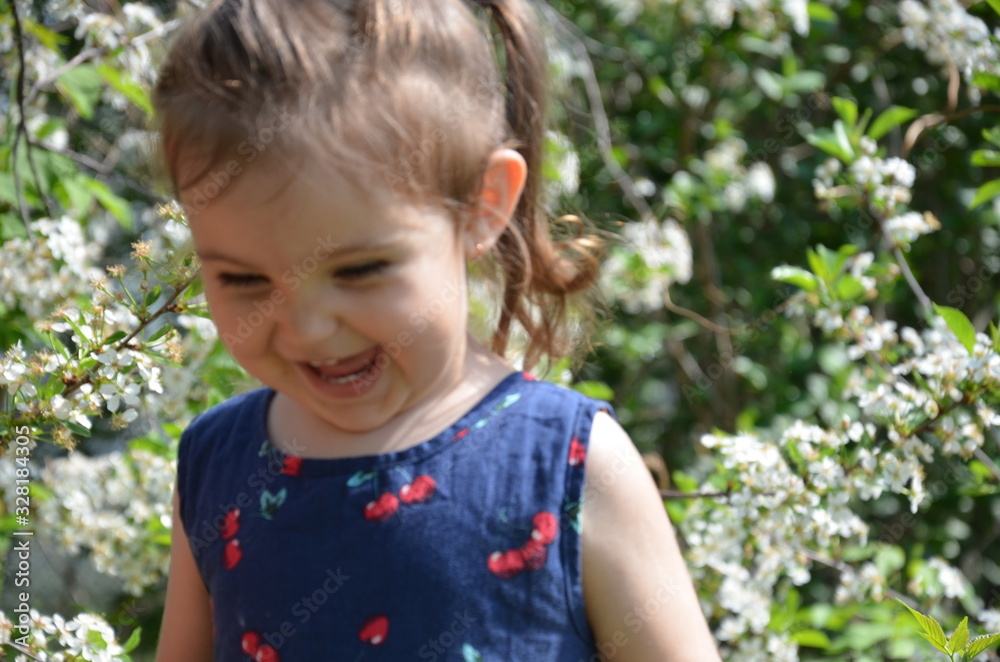 A beautiful girl stands among the flowering trees. Lovely cute little girl in red sunglasses spring blooming garden a tree with white flowers. Happy childhood, the awakening of nature Portrait Romance A beautiful girl stands among the flowering trees. Lovely cute little girl in red sunglasses spring blooming garden a tree with white flowers. Happy childhood, the awakening of nature Portrait Romance