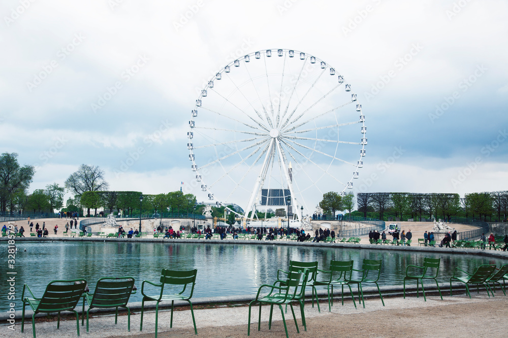 Paris touristic square with garden, sculpture and big ferris wheel on cloudy sky Paris touristic square with garden, sculpture and big ferris wheel on cloudy sky
