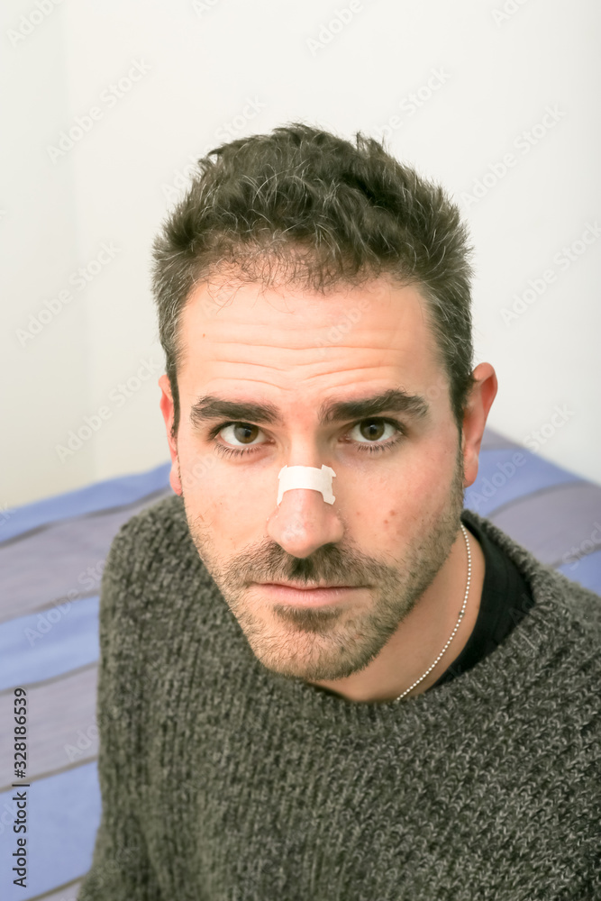Man satisfied using a nasal strip. External nasal dilator strip or