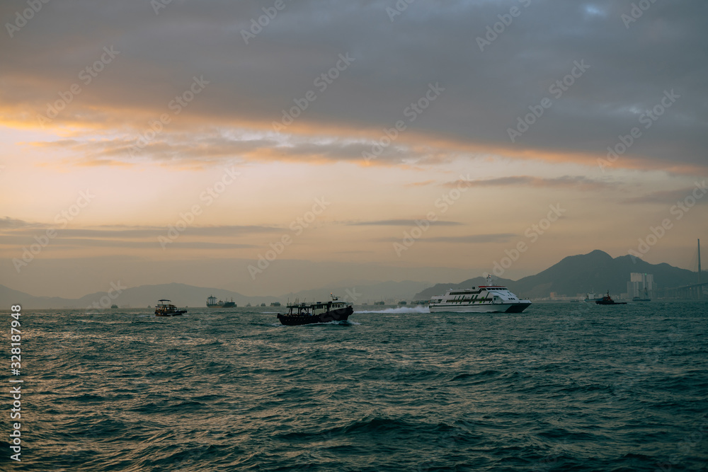 Boats sailing in Hong Kong river with island in the background