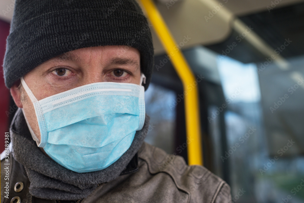 Portrait of man  with medical mask to protect against the corona virus in the public tramway