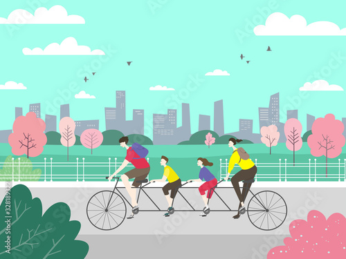 Happy family riding a tandem bicycle with four seats in the park on the background of the city landscape.