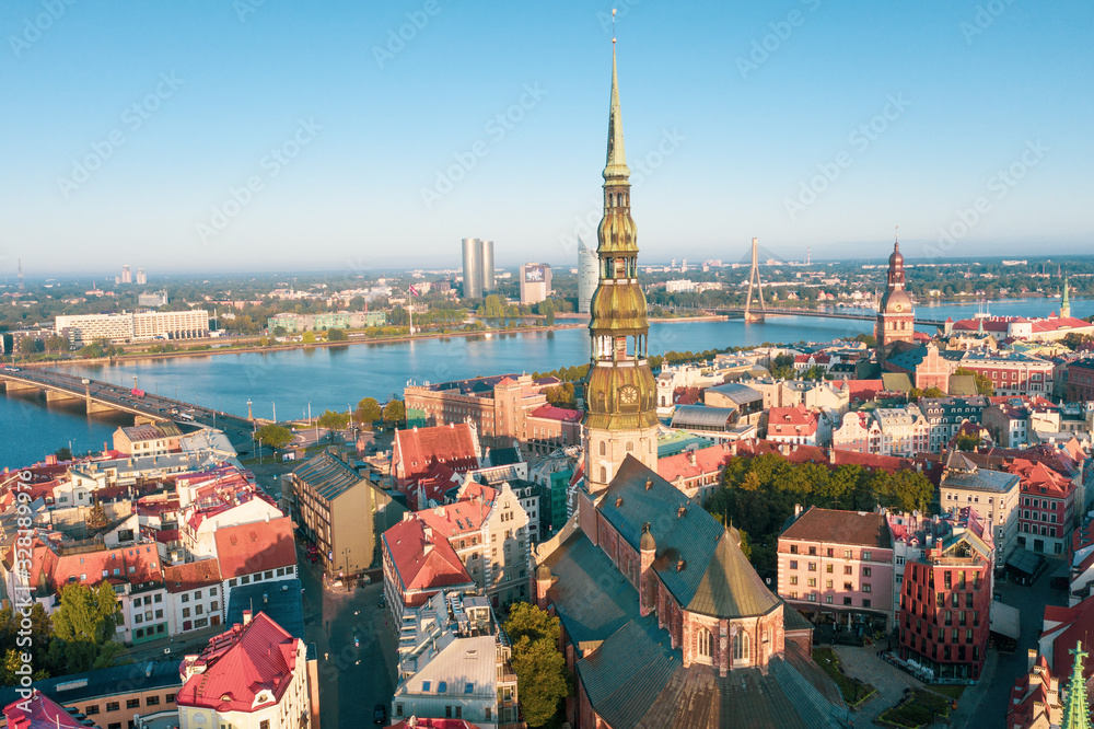 Aerial view photo from flying drone panoramic  to St. Peter's Church and the Old Town on the background of the Daugava River and downtown on a beautiful early morning sunrise (series)