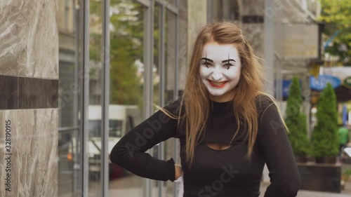 Funny female mime in street shows pantomime photo