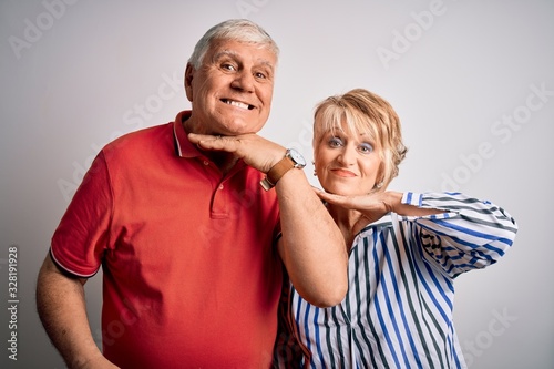 Senior beautiful couple standing together over isolated white background cutting throat with hand as knife, threaten aggression with furious violence