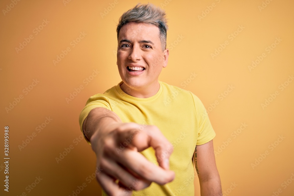 Young handsome modern man wearing yellow shirt over yellow isolated background pointing displeased and frustrated to the camera, angry and furious with you