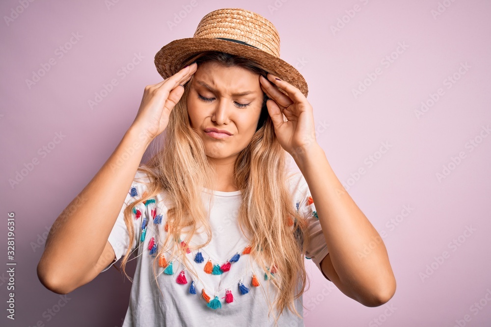 Young beautiful blonde woman wearing t-shirt and hat over isolated pink background suffering from headache desperate and stressed because pain and migraine. Hands on head.