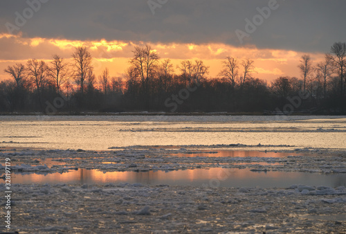 River Ice Sunrise. Ice flowing down the Fraser River in winter. Richmond, British Columbia, Canada.