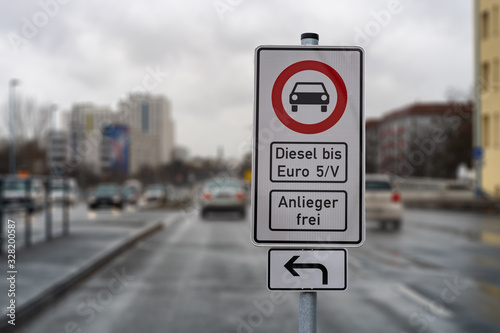 german street sign diesel driving ban in the downtown with a blurred background of city traffic, cars, traffic lights and buildings