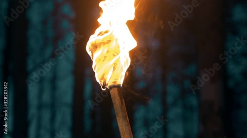 Handmade torch - piece of cloth burning on the stick - waving with the torch photo