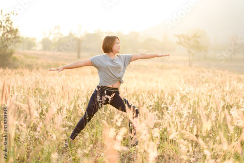 Young woman do yoga on a field