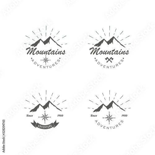 Black and white set of logos adventure and recreation in the mountains. Vector illustration of mountains, rays, crossed axes and text with ribbon. Advertising expeditions to the mountains.