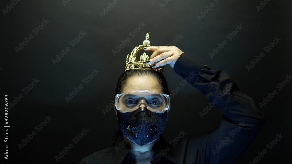 African American female protected in urban black air mask wearing crown or corona on the head. Covid-19 infection concept. Depiction of deadly corona virus 2019-nCoV, pandemic in China concept. African American female protected in urban black air mask wearing crown or corona on the head. Covid-19 infection concept. Depiction of deadly corona virus 2019-nCoV, pandemic in China concept.