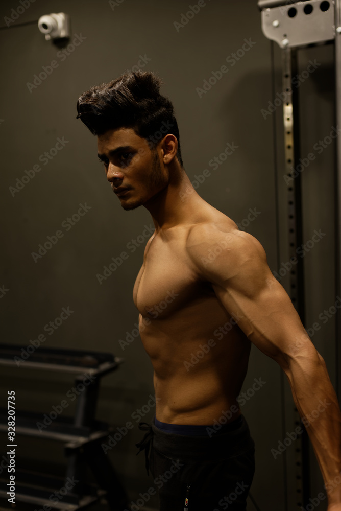 An young and handsome Indian Bengali brunette man with muscular body doing exercise in a multi gym. Fitness and Indian lifestyle. An young and handsome Indian Bengali brunette man with muscular body doing exercise in a multi gym. Fitness and Indian lifestyle.