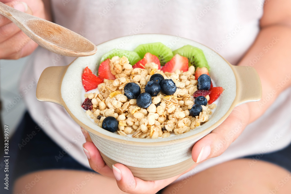 Hand of woman holding bowl of fresh strawberry and yogurt .Concept of healthy diet and weight control Hand of woman holding bowl of fresh strawberry and yogurt .Concept of healthy diet and weight control